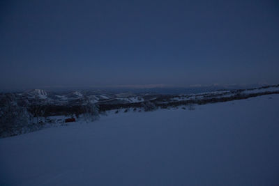 Scenic view of snowcapped mountains against clear blue sky during winter