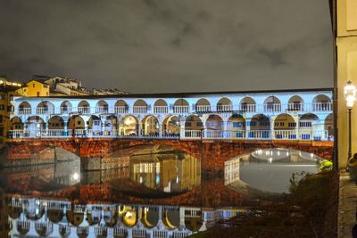 Arch bridge over river against building