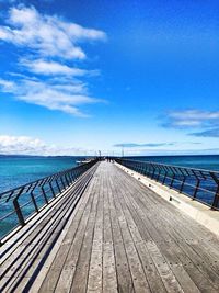 Pier on sea against cloudy sky