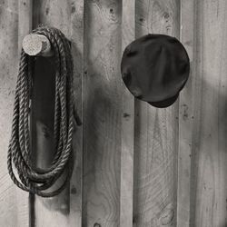 Close-up of tied hanging on rope against wall