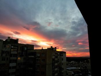 Buildings in city against sky during sunset