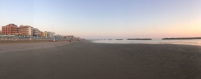 Scenic view of beach against clear sky during sunset