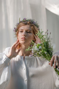 Portrait of a beautiful young woman holding flower bouquet