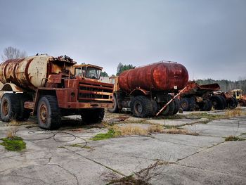 Abandoned tractors against sky