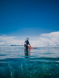 Man swimming in sea against sky