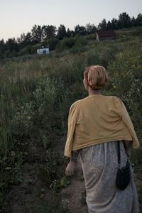 Rear view of man on field against trees