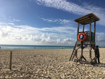 Lifeguard hut at beach against sky