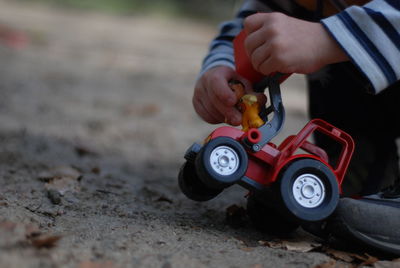 Boy playing with toy car in city