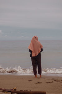 Rear view of woman standing on beach