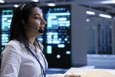 Portrait of young woman using mobile phone in office