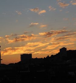 Silhouette buildings against sky during sunset