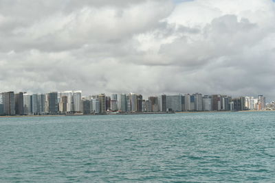 Sea and cityscape against sky