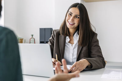 Smiling recruiter taking candidate's interview at desk