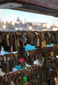 Close-up of padlocks on railing against bridge