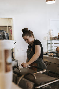 Side view of woman preparing food at home