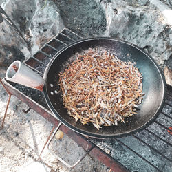 High angle view of fish in pan on barbecue