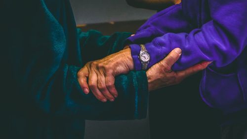 Close-up of hands holding blue purple