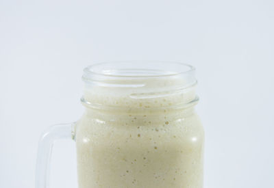 Close-up of drink in jar against white background