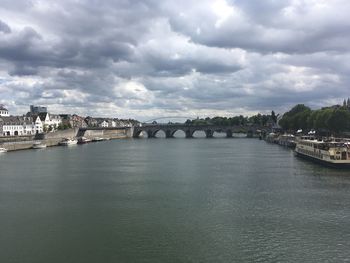 Bridge over river against sky in city