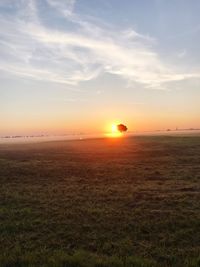 Scenic view of field against sky during sunset