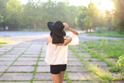 Rear view of woman standing on footpath