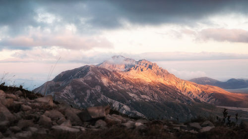 Scenic view of snowcapped mountains against dramatic sky