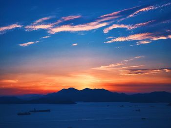 Scenic view of sea against cloudy sky during sunset