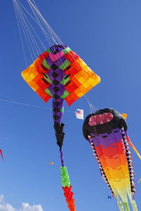 Low angle view of lanterns hanging against blue sky