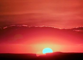 Scenic view of silhouette mountains against romantic sky at sunset