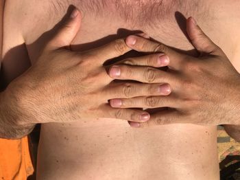 Midsection of shirtless man in sunny day