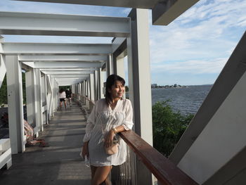 Full length of young woman standing against building