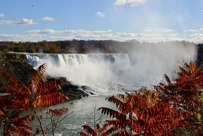 Scenic view of waterfall against sky