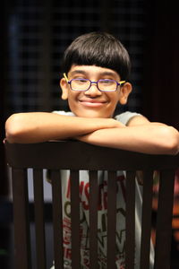 Portrait of young boy sitting on railing