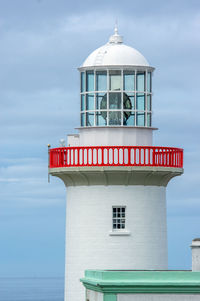 Lighthouse by sea against sky