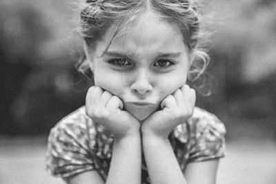 Close-up portrait of sad girl with hands on chin