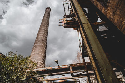 Low angle view of abandoned factory against sky