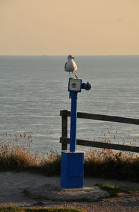 Lifeguard hut on beach against sky during sunset