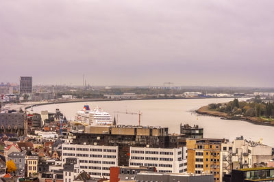 High angle view of river amidst buildings in city against sky