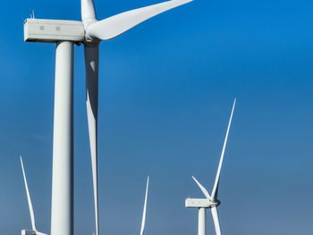 Low angle view of windmill against blue sky