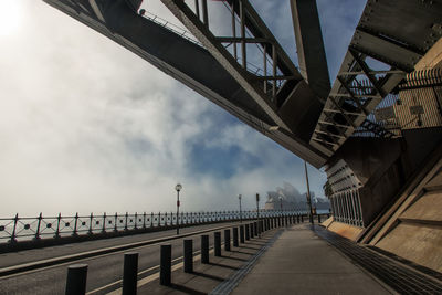 Bridge over river in city against sky