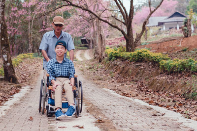 Rear view of father and son riding in park