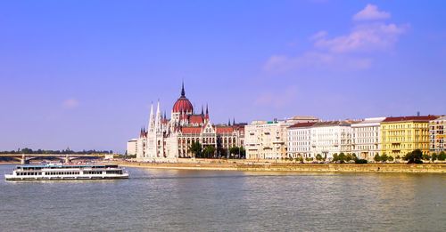 Tourist boat on danube river near hungary parliament palace in summer