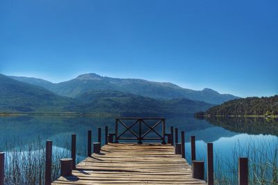 Pier over lake against blue sky