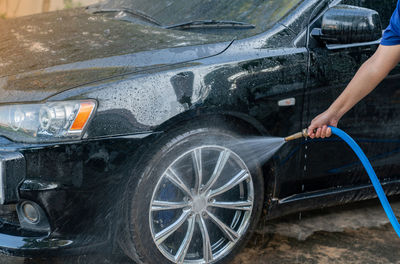 Woman washing her car at home.car wash self-service.