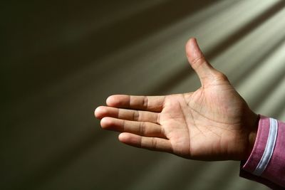 Close-up of human hand against rays