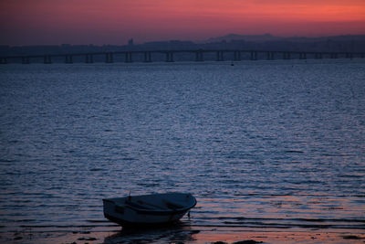 Boat in sea against sky during sunset