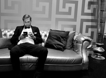 Handsome man using phone on sofa at home