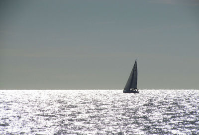 Sailboat sailing on sea against sky