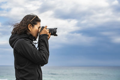 Woman taking a photograph with a digital camera at the 12 apostle's