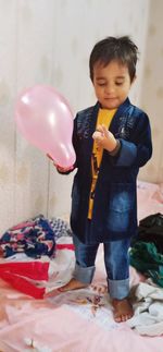 Cute boy with balloons at home